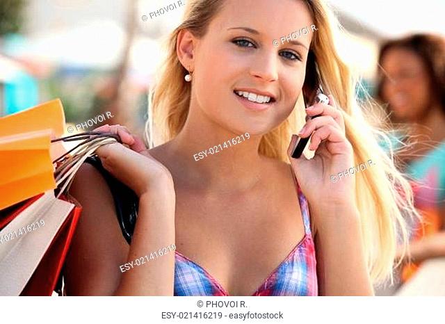 Young woman talking on her mobile phone while shopping