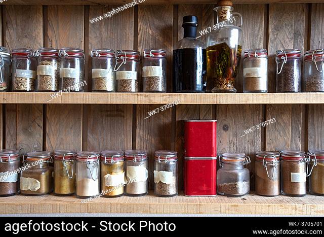 Bottles with spices and seasonings in wooden rack. Various different organic herbs for in the kitchen vintage look Many