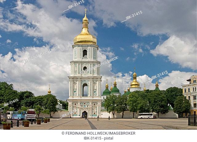 Ukraine Kiev view to Sophien place with big belltower and the shining golden domes of Sophien cathedral 1054 tourists visitors road with cars historical...