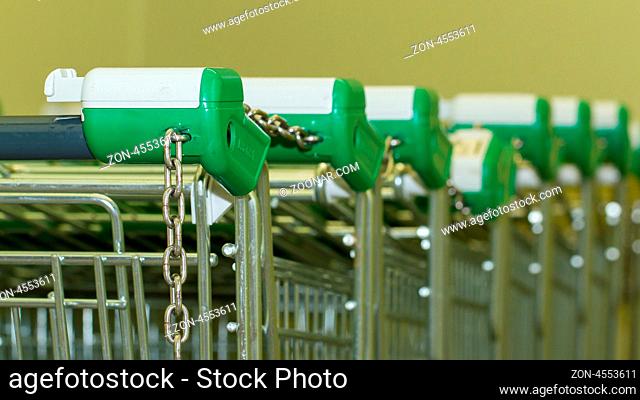 A close-up of a row of shopping Trolleys
