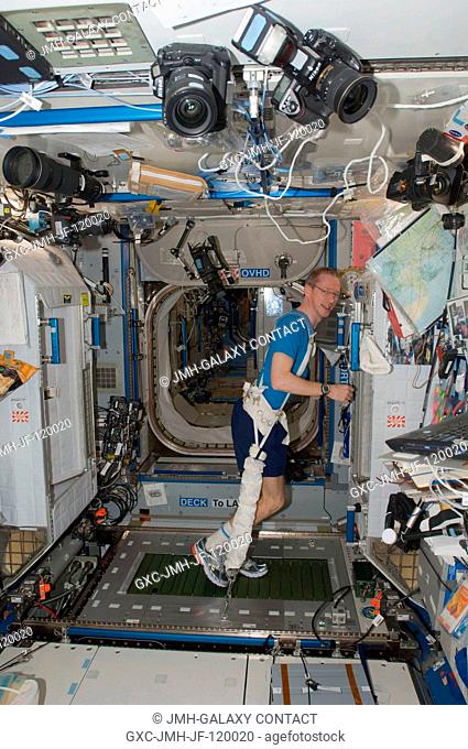 European Space Agency astronaut Frank De Winne, Expedition 21 commander, equipped with a bungee harness, exercises on the Combined Operational Load Bearing...