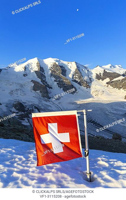 Switzerland flag with Palù Peaks and Vedret Pers Glacier in the background. Diavolezza Refuge, Bernina Pass, Engadin, Graubünden, Switzerland, Europe