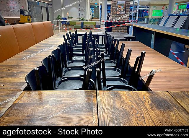 Closed catering business, empty tables and chairs are put together and stacked on top of one another. Gastronomy is threatened by the corona pandemic