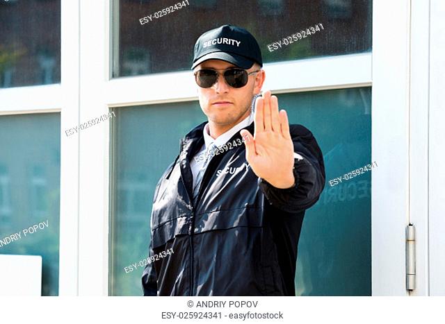 Close-up Of A Male Security Guard Making Stop Sign With Hand Wearing Sunglasses