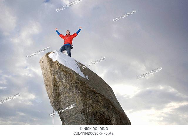 climber celebrating on snow capped peak