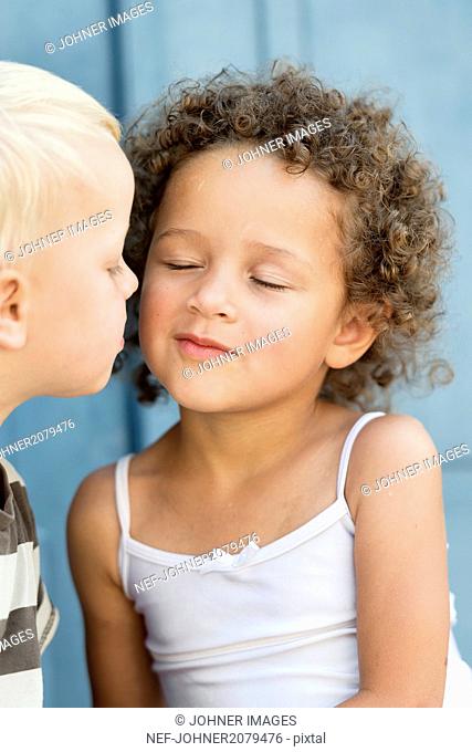 Small boy kissing girl