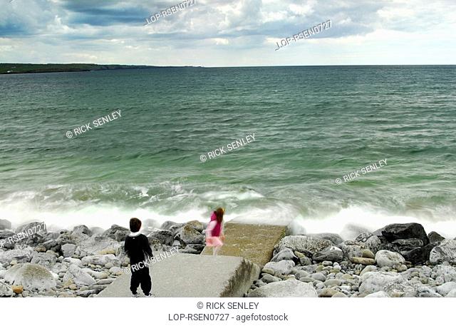 Republic of Ireland, County Clare, Lahinch, Children playing on the rocks at Lahinch in County Clare
