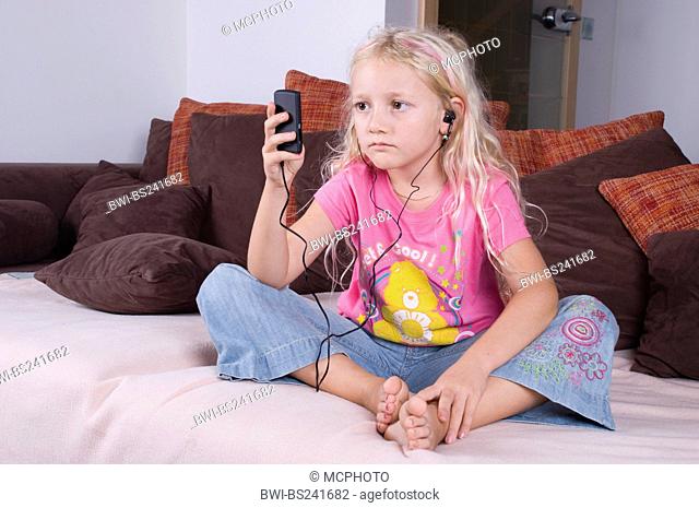 girl with MP3-Player sitting on a bed
