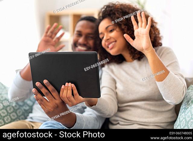 close up of happy couple with tablet pc at home