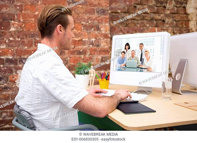 Composite image of happy business people gathered around laptop looking at camera