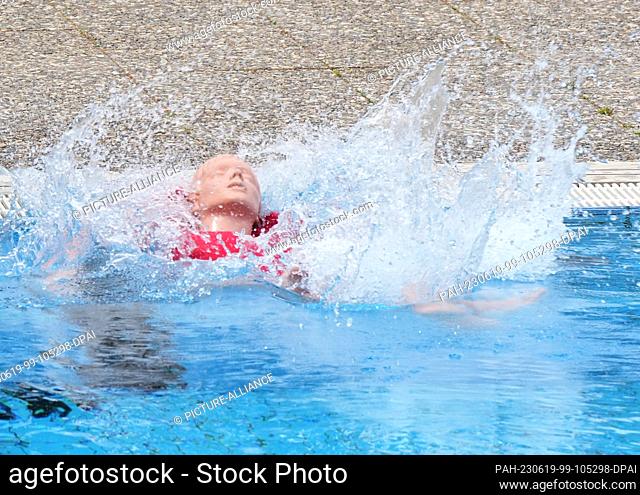 14 June 2023, Berlin: A lifeguard threw a doll into the water during the pre-swim of potential lifeguards at the Humboldthain summer pool