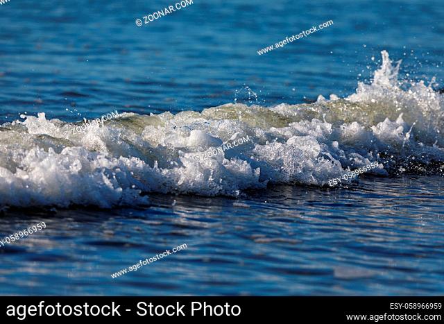 small wave in the blue ocean of skagerrak coming in to the beach at Lista, Norway