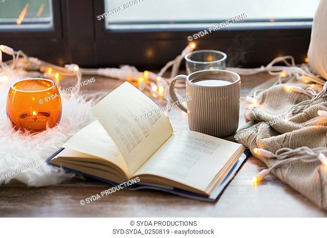 book and coffee or hot chocolate on window sill
