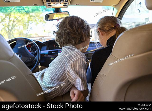 Young boy looking at camera in parked car