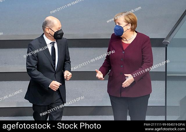dpatop - 11 November 2021, Berlin: Olaf Scholz, SPD candidate for Chancellor and Federal Minister of Finance, and Chancellor Angela Merkel (CDU) talk during the...