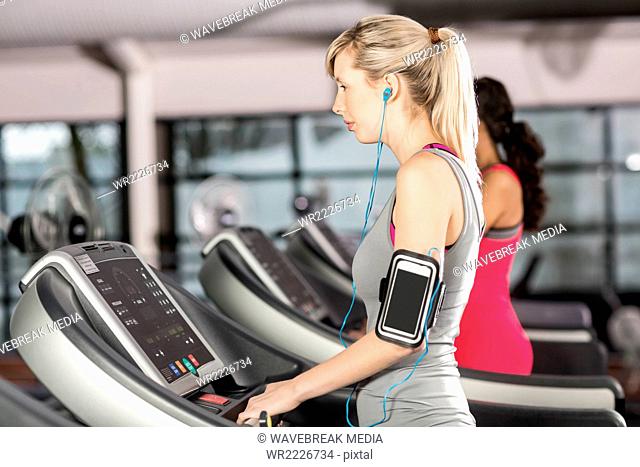 Fit woman on treadmill with headphones