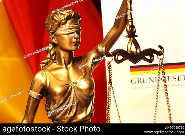 Close-up of a Justitia in front of a german basic law book