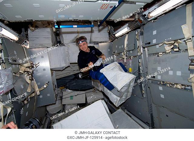Canadian Space Agency astronaut Robert Thirsk, Expedition 20 flight engineer, holds a storage container with his legs while floating freely in the Leonardo...