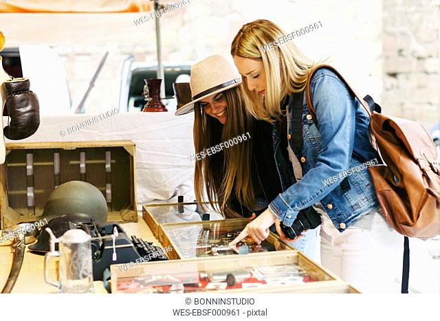 Two young women at a stall on flea market