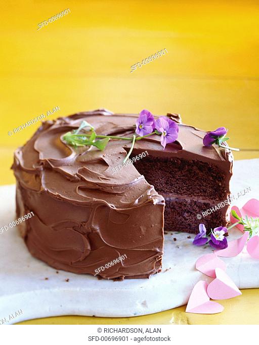 Chocolate Cake with Purple Flowers and Pink Paper Hearts, Slice Removed