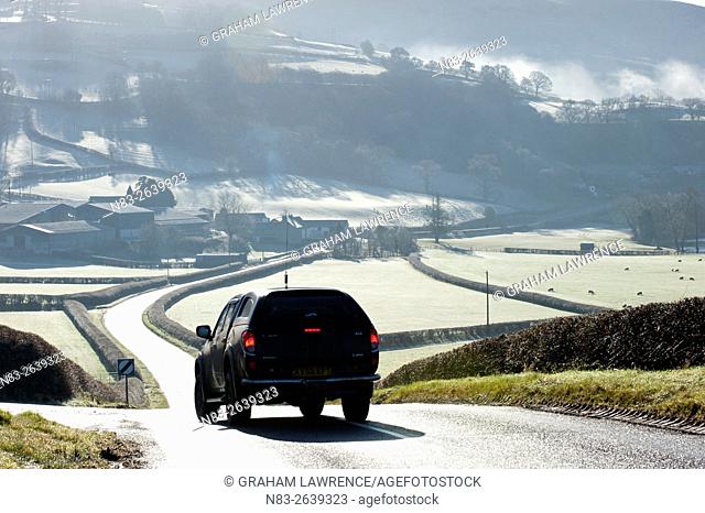 A motorist drives through a frosty landscape along the road between Aberedw and Builth Wells, Powys, UK