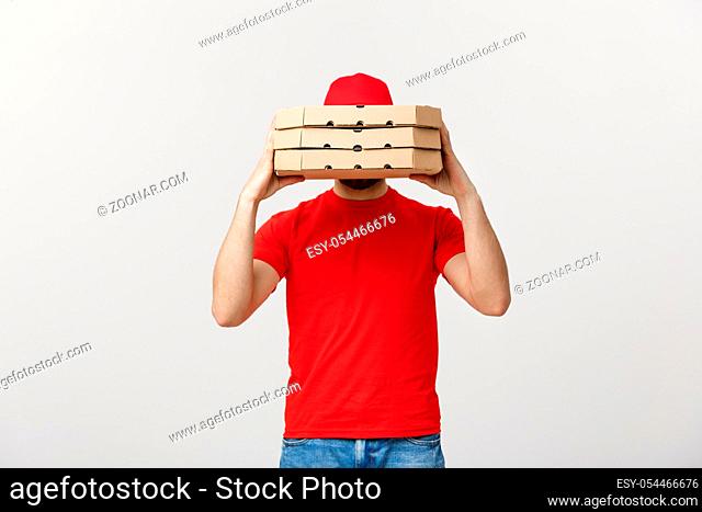A Deliveryman hidden behind a large stack of pizza boxes he is carrying. Isolated over grey background