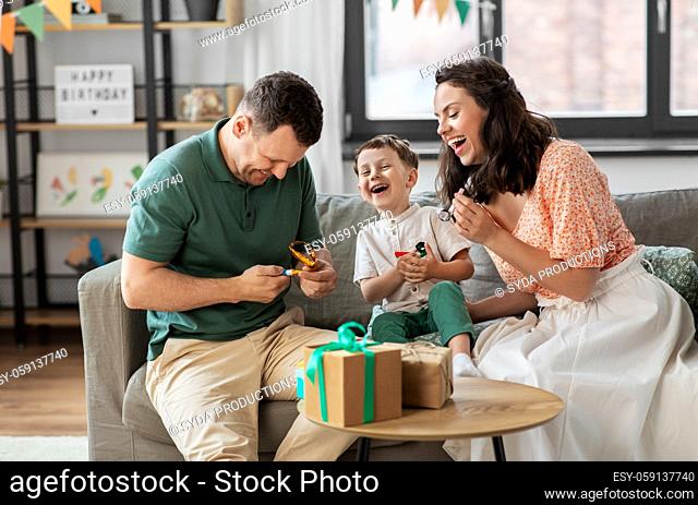 happy family with gifts and party blowers at home