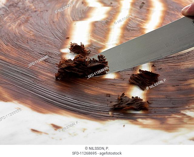 Chocolate curls being made using a knife