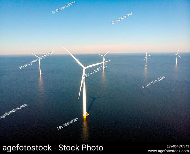 Windmill farm with colorful tulip fields in the Noordoostpolder netherlands, Green energy windmill turbine at sea and land Flevoland