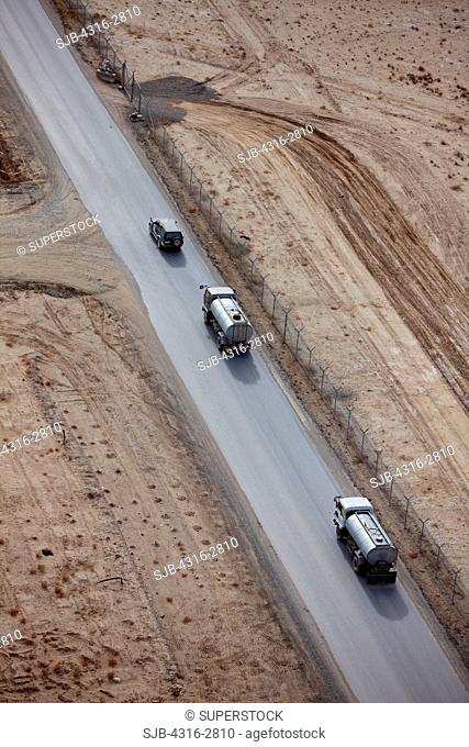 An aerial view of a convoy of fuel trucks on a paved highway, in Kandahar Province, Afghanistan