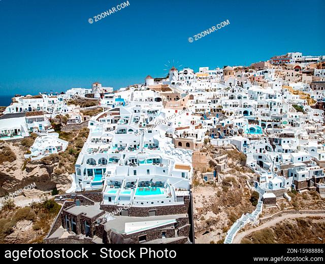 Drone view over Santorini, aerial view over the whitewashed village of Oia with luxury vacation resort with infinity pools in Santorini Greece. Europe