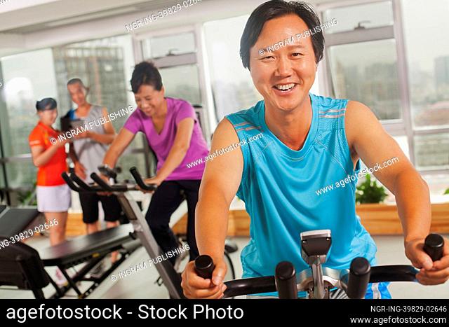 Man smiling and exercising on the exercise bike