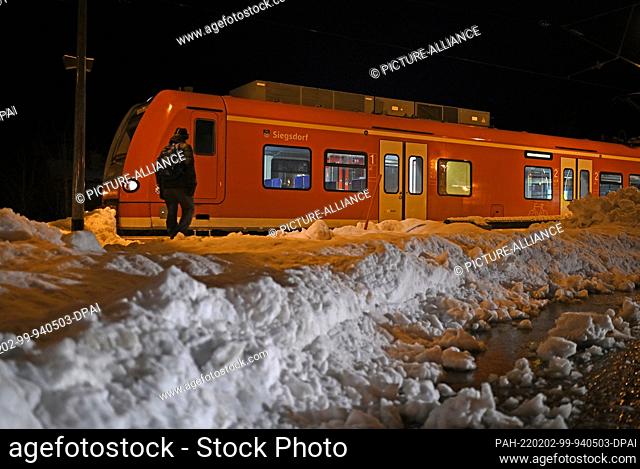 02 February 2022, Bavaria, Ruhpolding: A train stands between mountains of snow at Ruhpolding station in the early morning. Photo: Uwe Lein/dpa