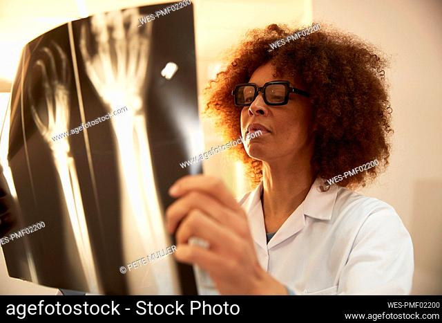 Doctor with eyeglasses examining X-ray in medical clinic at hospital