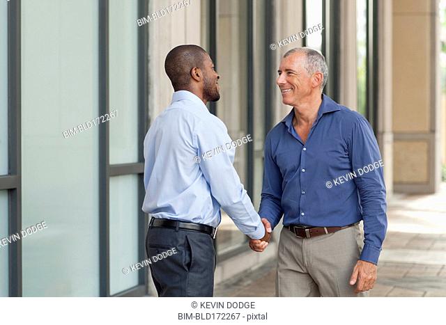 Businessmen shaking hands in city