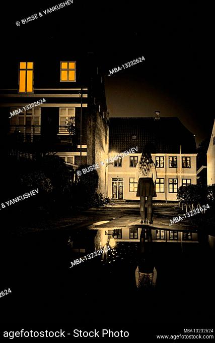 Woman with a short skirt in a small Danish town at night