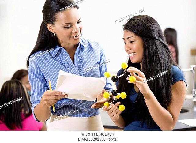 Teacher explaining chemistry model to student
