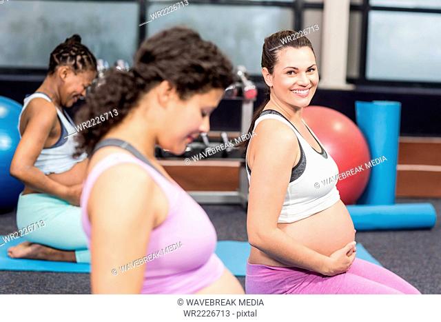 Pregnant woman doing exercise on mat