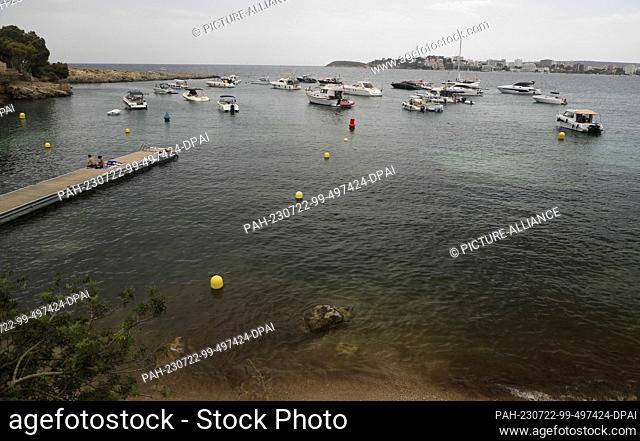 22 July 2023, Spain, Calvia: Boats anchor on the beach at Punta Negra on Mallorca. According to a study, the Mediterranean Sea is warming up faster and faster...