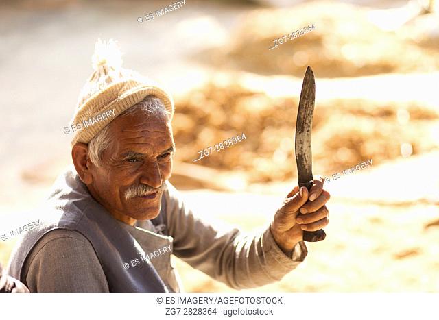 Nepali farmer holding a traditional Khukuri (Kukri) knife