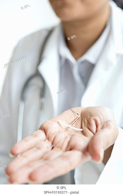 Female doctor holding an IUD