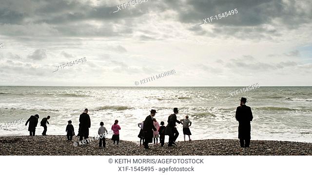 Orthodox Hassidic jews on summer holiday on the beach at Aberystwyth Wales UK