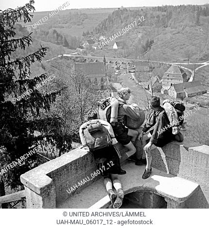 Drei Hitlerjungen schauen auf ein Dorf, Deutschland 1930er Jahre. Three Hitler youths watching a village from a watchout, Germany 1930s