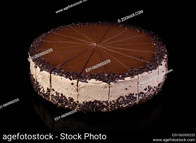 Chocolate cake cut into portions on a dark background