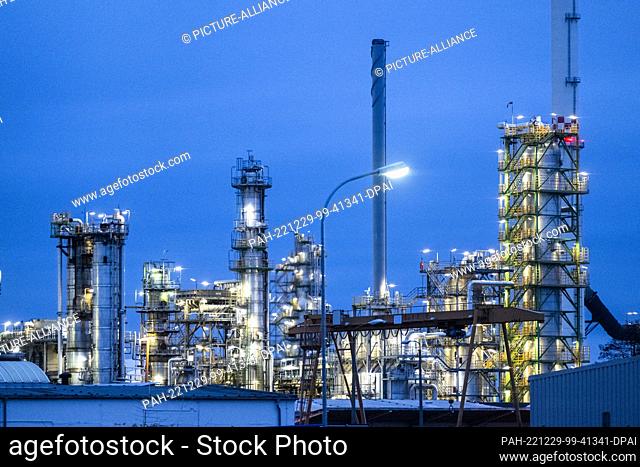 28 December 2022, Brandenburg, Schwedt/Oder: The facilities of the oil refinery on the industrial site of PCK-Raffinerie GmbH are illuminated in the evening