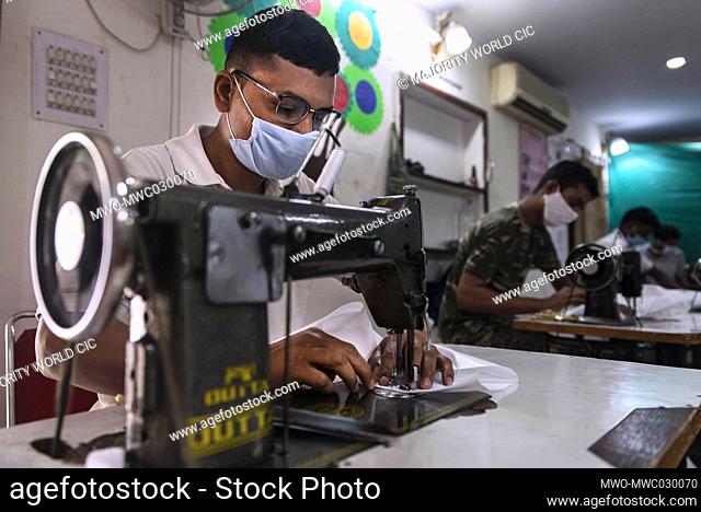 Central Reserve Police Force (CRPF) personnel use sewing machines while manufacturing protective suits at the CRPF Northern Sector staff camp in New Delhi