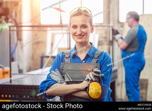 Workers in a metal workshop, man and woman
