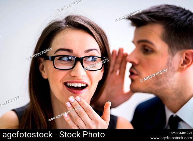 Close-up Of Businessman Whispering Into Female Partner's Ear