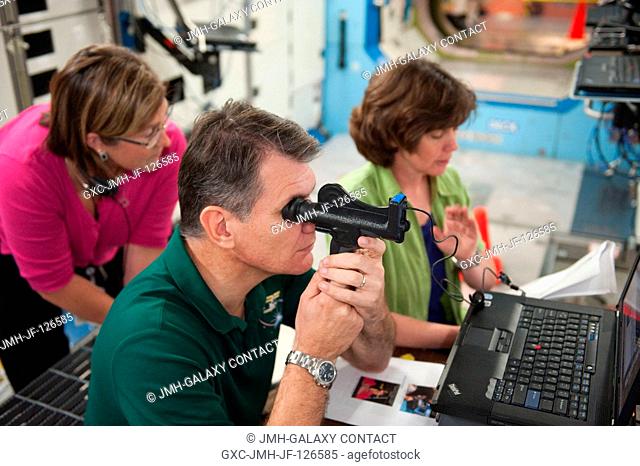 European Space Agency (ESA) astronaut Paolo Nespoli and NASA astronaut Catherine Coleman (right background), both Expedition 2627 flight engineers
