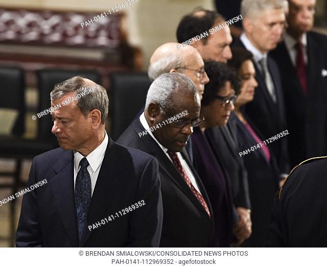 Member of the Supreme Court, Chief Justice, John Roberts (L), reacts during the service for former US President George H.W